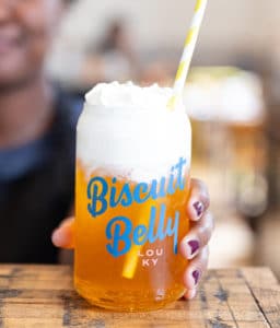 A delicious drink with whipped cream inside a branded Biscuit Belly cup